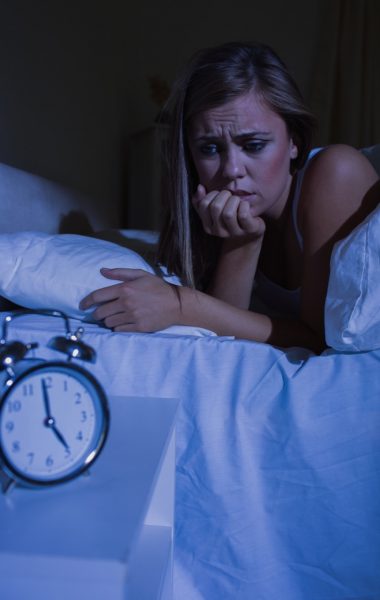 Unquiet woman in the bed at night in the bedroom